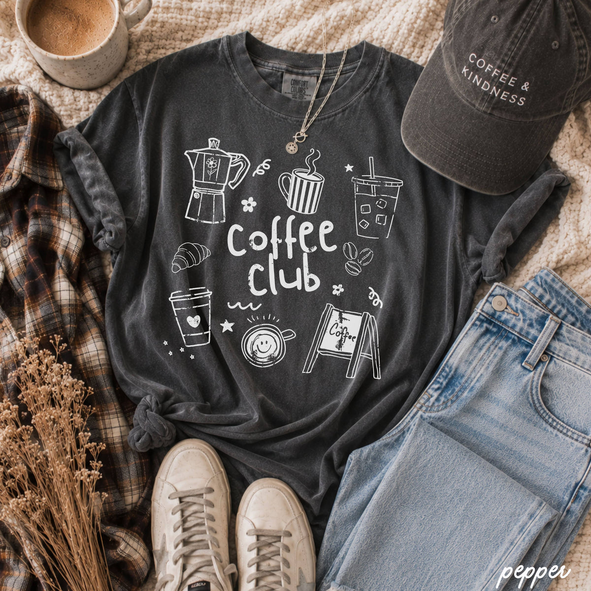 Dark gray t-shirt with 'Coffee Club' design, surrounded by coffee-themed items on a textured surface at the rustic barn in killingworth ct