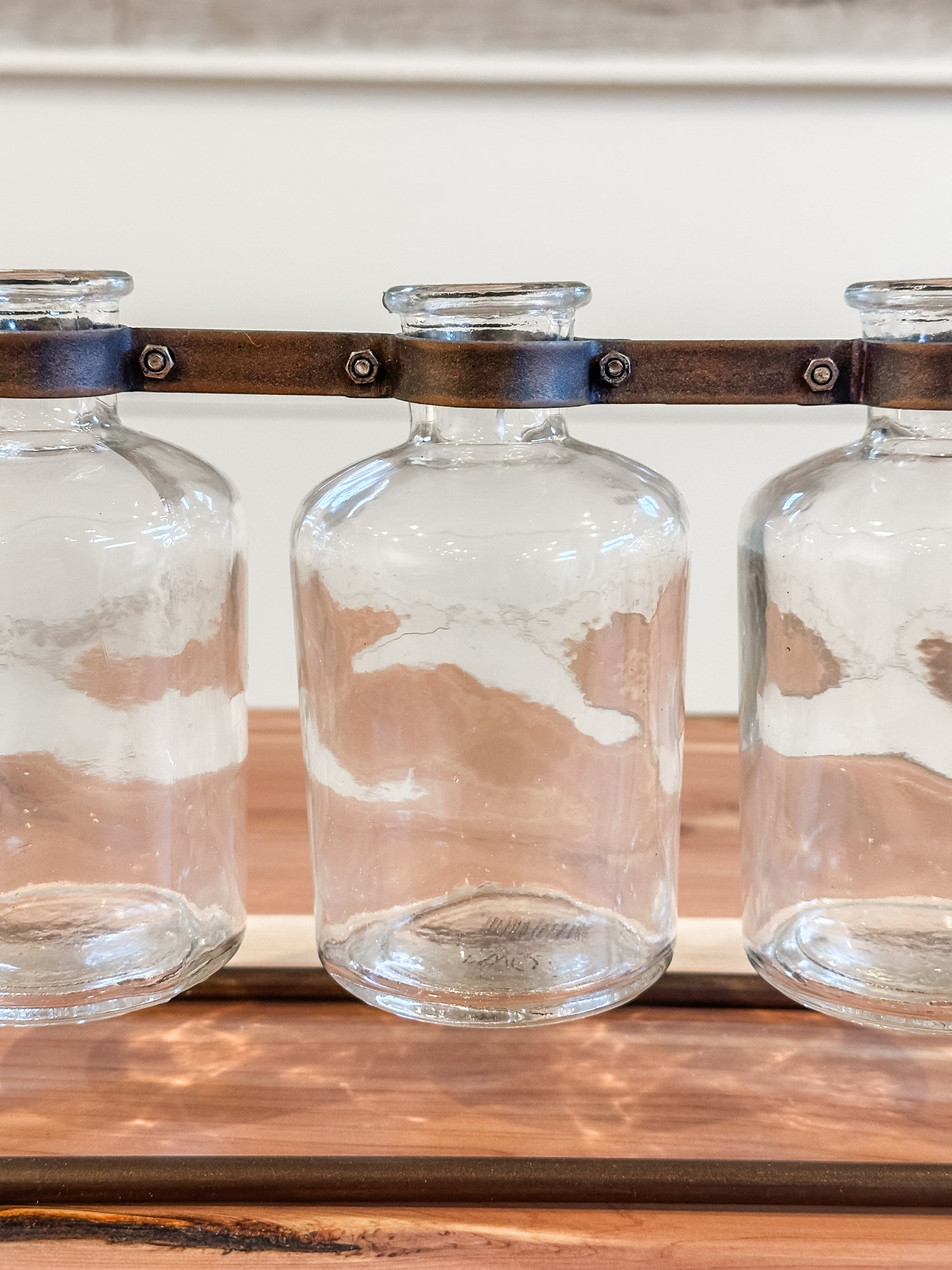 3 glass bottle vases on hinged metal stand at The Rustic Barn in Killingworth, CT