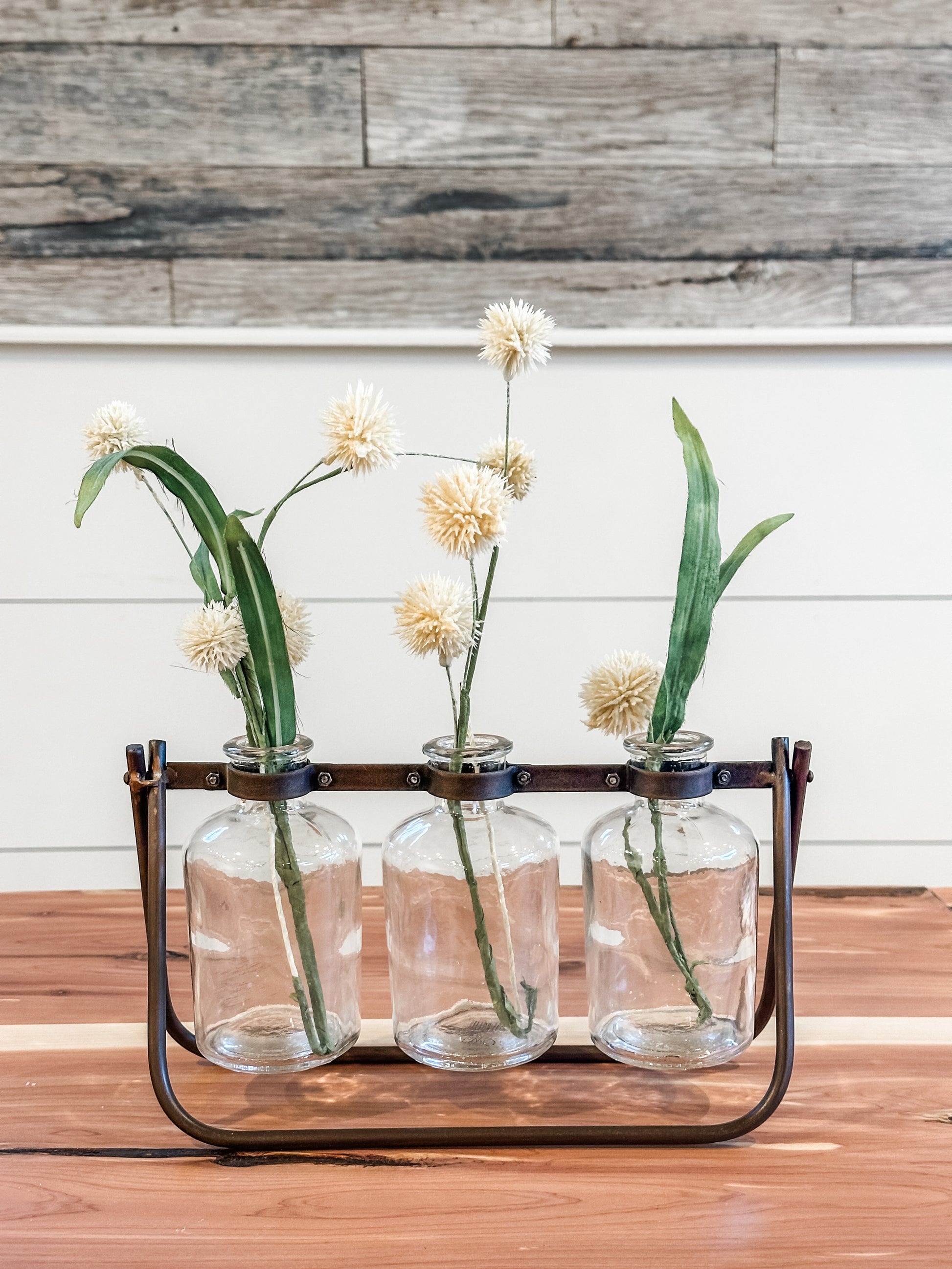 3 glass bottle vases on hinged metal stand at The Rustic Barn in Killingworth, CT