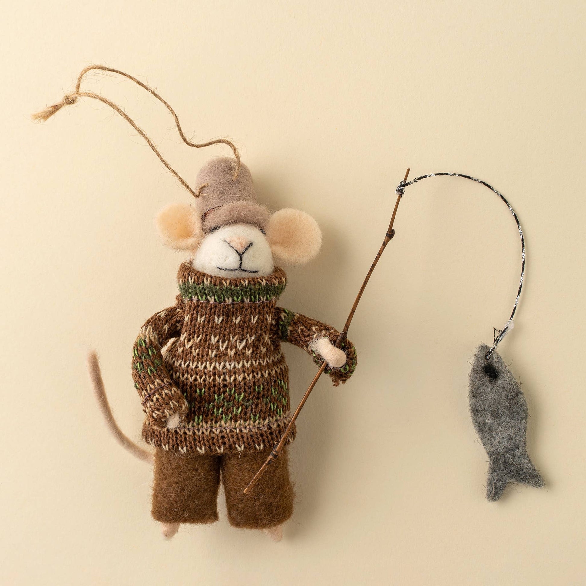 Decorative mouse ornament in a sweater with a fishing rod and fish on a beige background at the rustic barn in killingworth ct