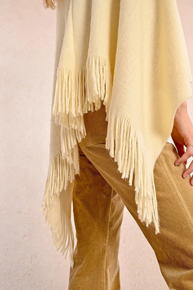 Cream colored cozy fall or winter poncho with fringe detail for sale at the rustic barn in killingworth, CT