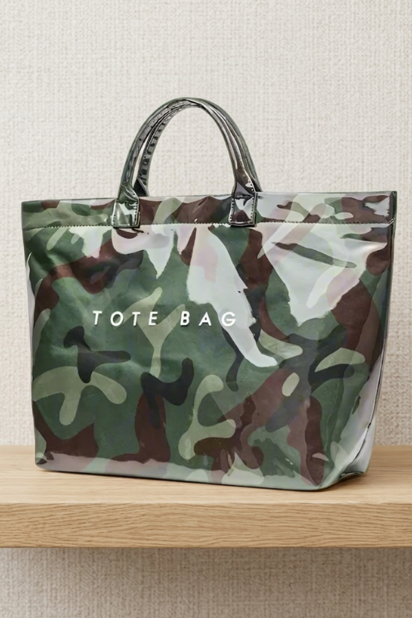 Camouflage tote bag with 'TOTE BAG' text on a wooden surface and light background