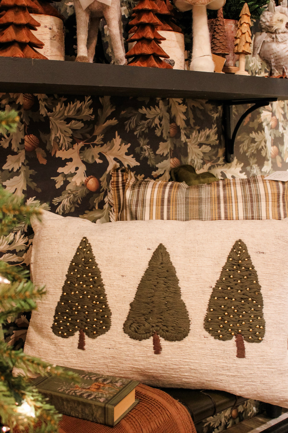 Cozy Christmas tree pillow with warm accents and brown and green colors. The perfect christmas homey pillow and seasonal accents such as christmas trees, sparkly mushrooms, and comfy blankets. All for sale at the rustic barn in killingworth, CT