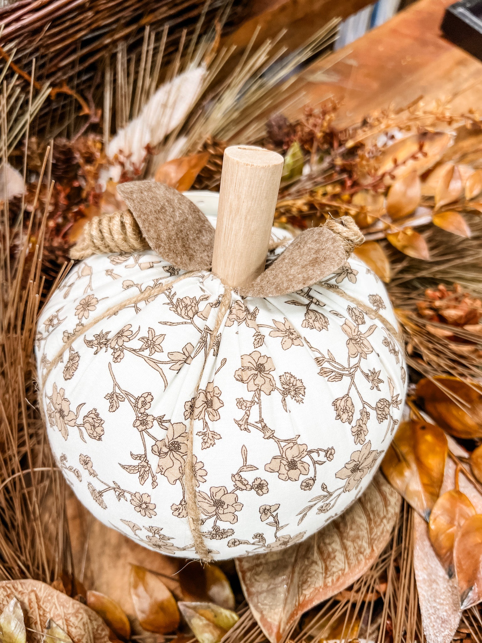 A decorative white pumpkin with a brown floral vine pattern at the rustic barn in killingworth ct