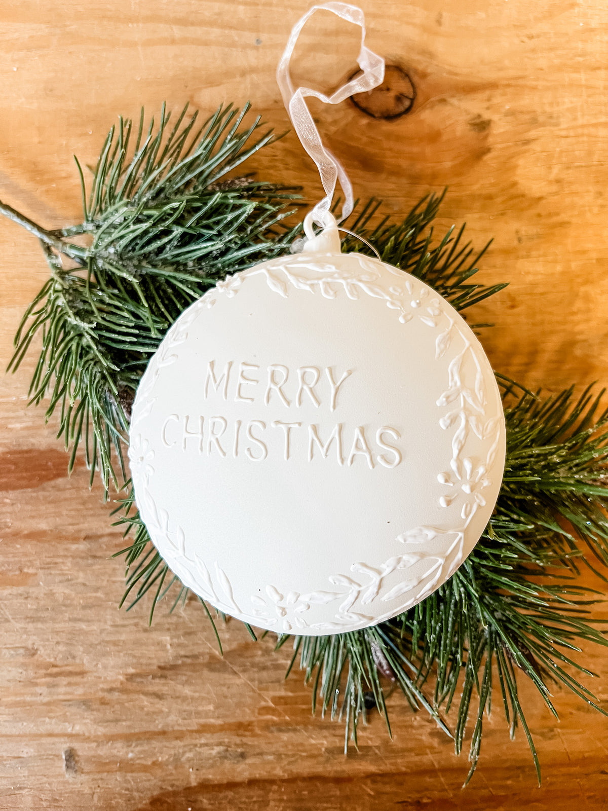 matt cream glass ornament with merry christmas written on it at the rustic barn in killingworth ct