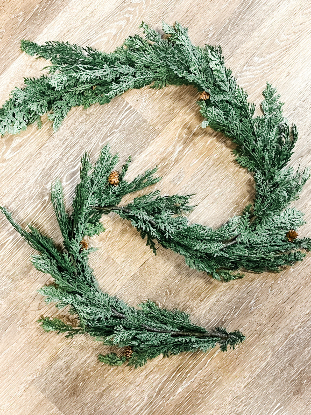 A green cypress and pinecone evergreen wreath made from pine branches with small pinecones at the rustic barn in killingworth, CT