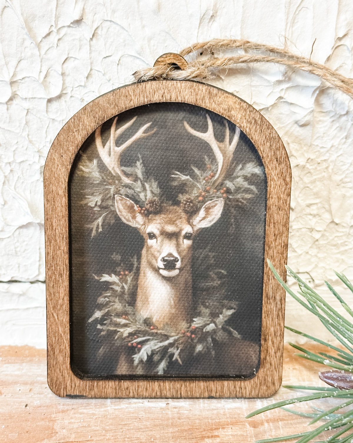 wood arched ornament with a deer and a wreath around it's neck at the rustic barn in killingworth ct