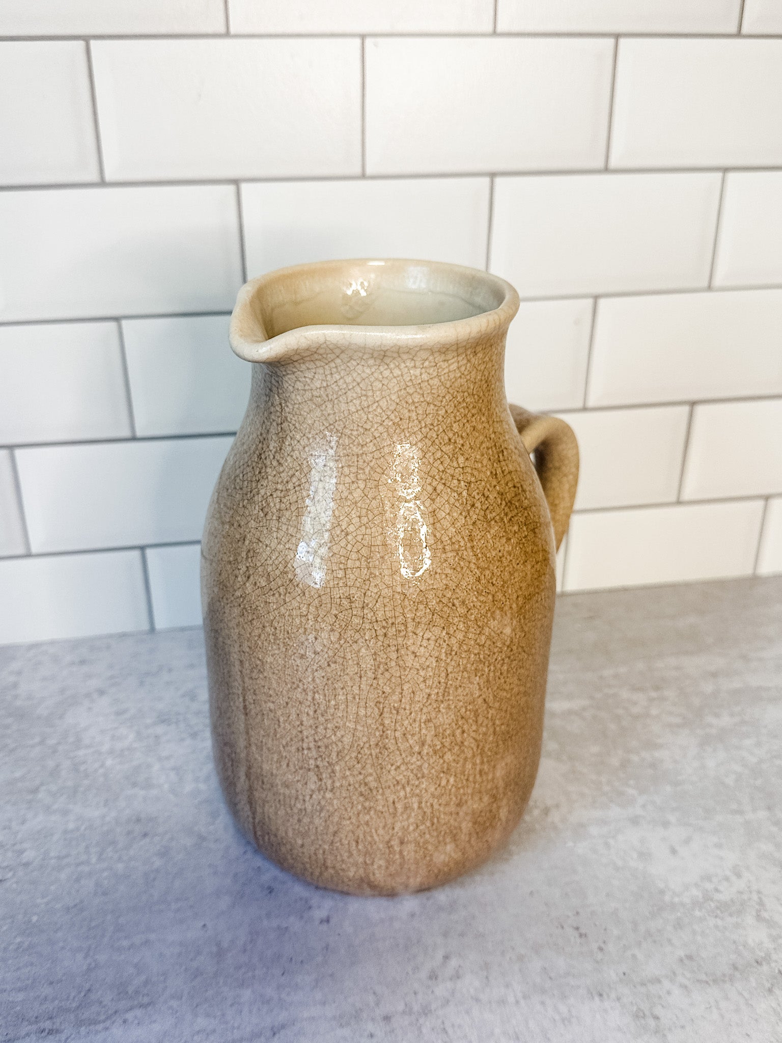 Distressed artisanal cream stoneware pitcher with reactive crackle glaze for sale at the rustic barn in killingworth, CT