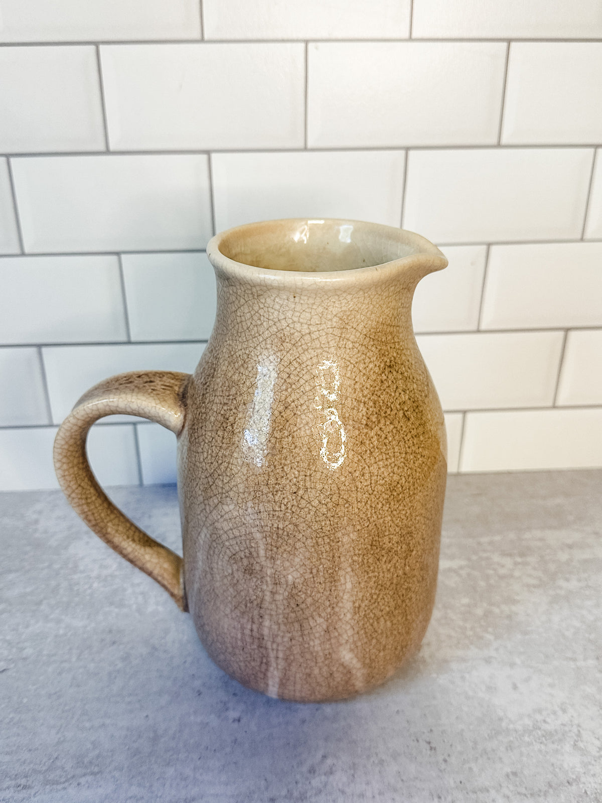 Distressed artisanal cream stoneware pitcher with reactive crackle glaze for sale at the rustic barn in killingworth, CT