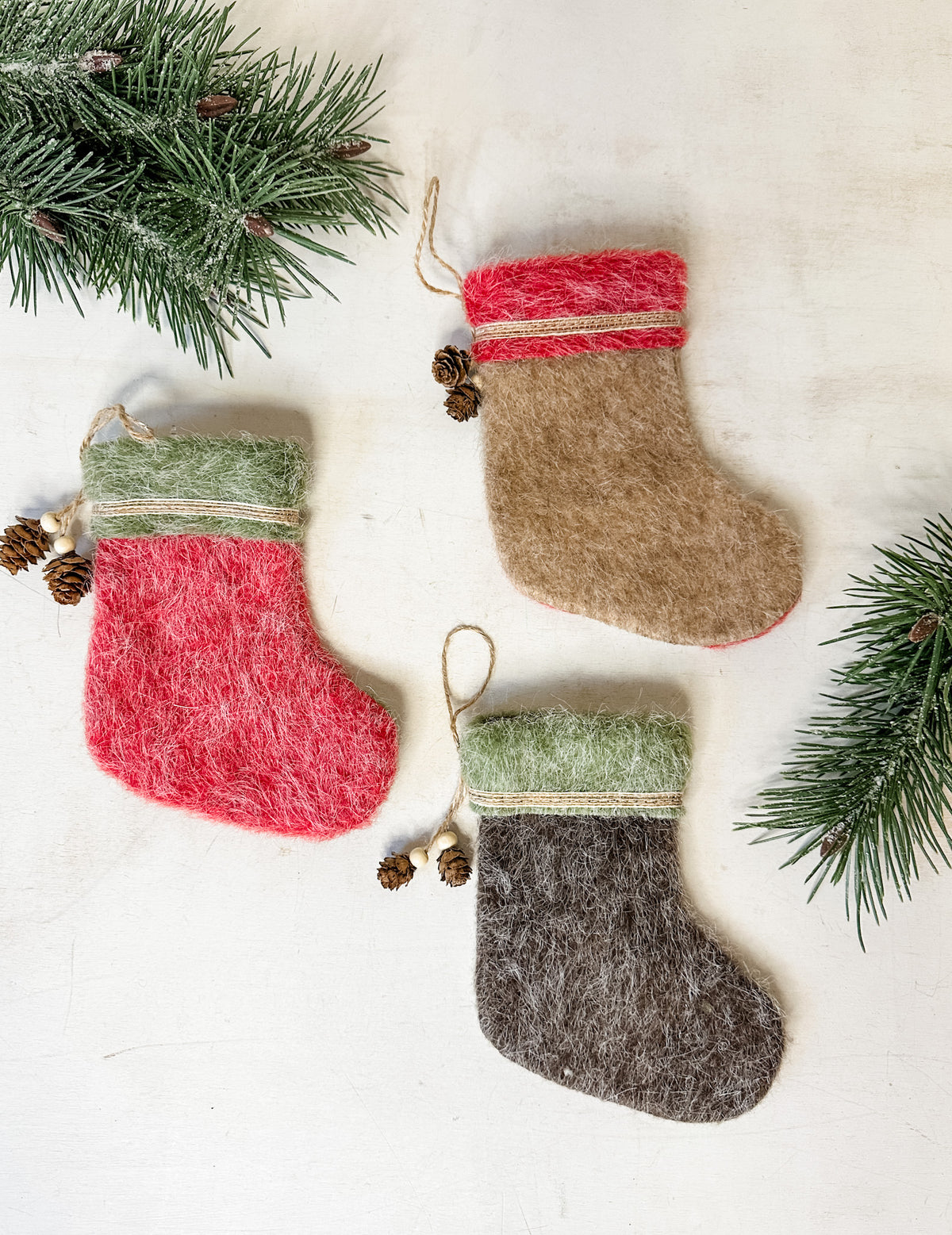 Felt stocking ornaments with natural pinecone detailing for sale at the rustic barn in killingworth, CT
