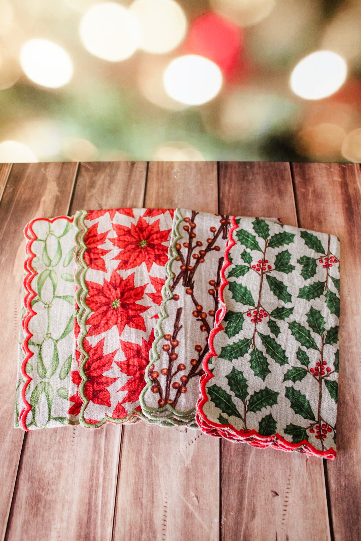 Festive green red and white holiday christmas napkins set of 4 with white berries, poinsettias, holly, red berries, and christmas prints with scalloped edge for sale at the rustic barn in killingworth, CT