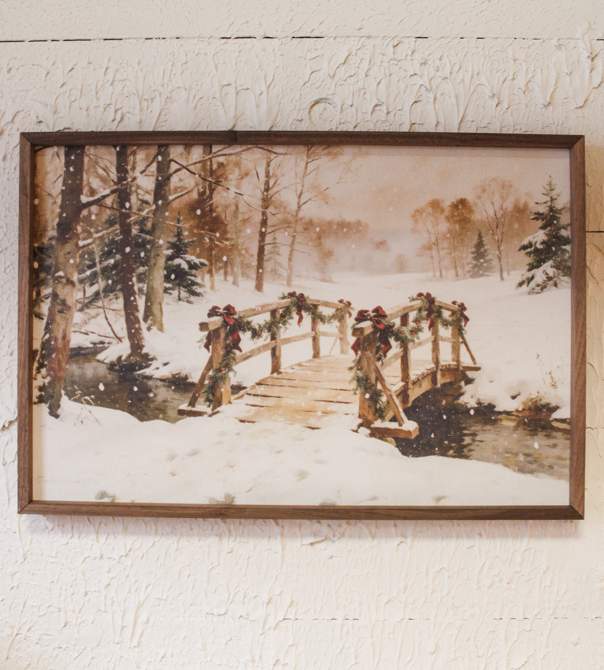 Festive winter bridge in snowy scene with red bows and evergreen garland for christmas wall art for sale at the rustic barn in killingworth, CT