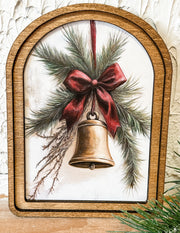 gold bell with red ribbon small arched wood framed print at the rustic barn in killingworth ct