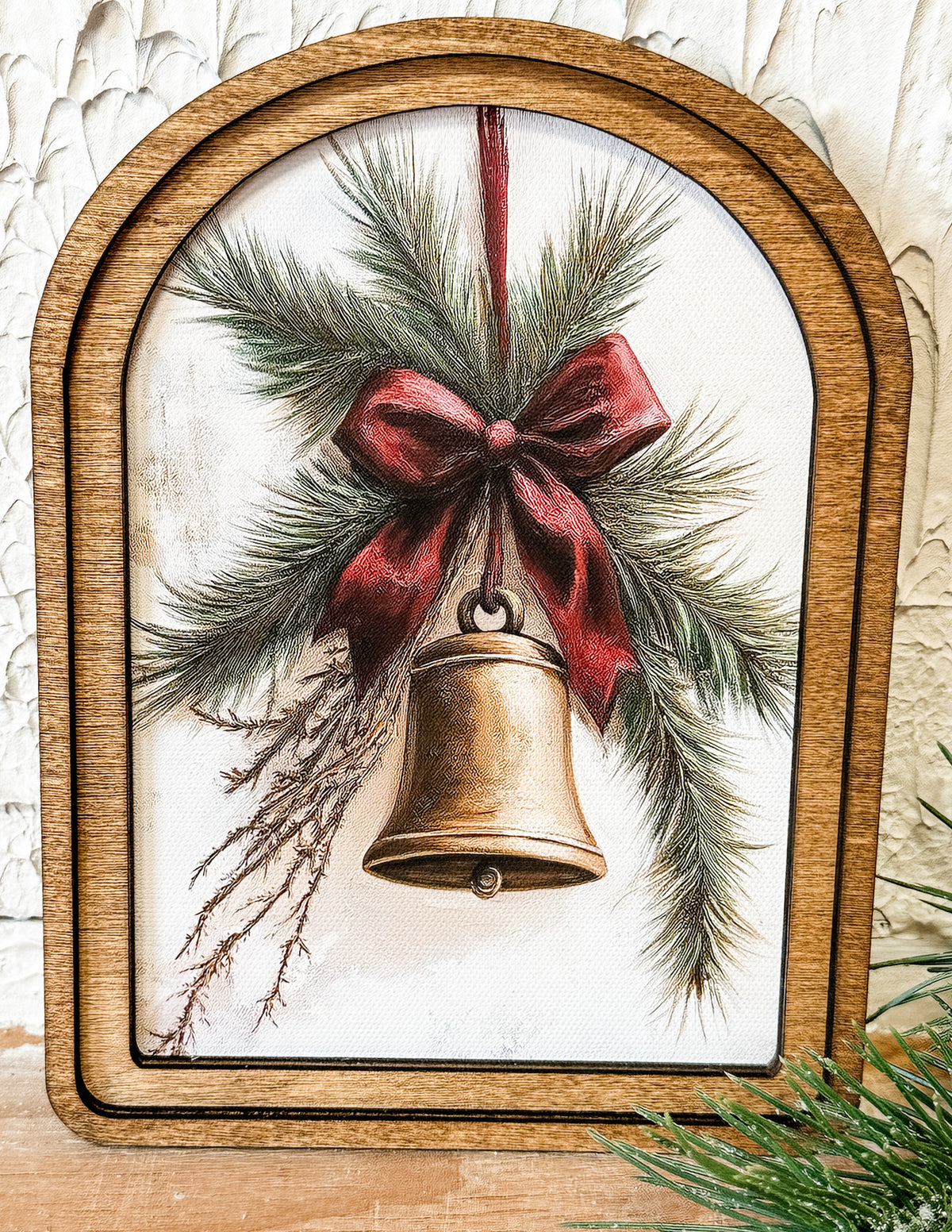 gold bell with red ribbon small arched wood framed print at the rustic barn in killingworth ct