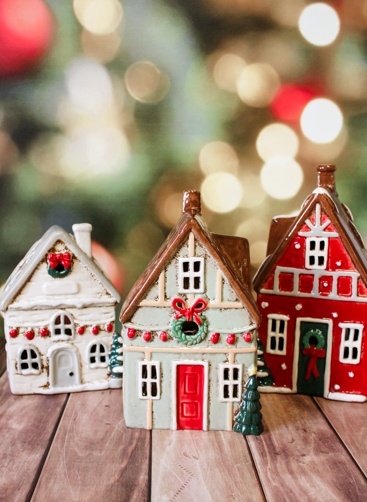 Hand painted holiday ceramic village houses with christmas trees, wreaths, bows, and lights with back open for candles and faux lights for sale at the rustic barn in Killingworth, CT