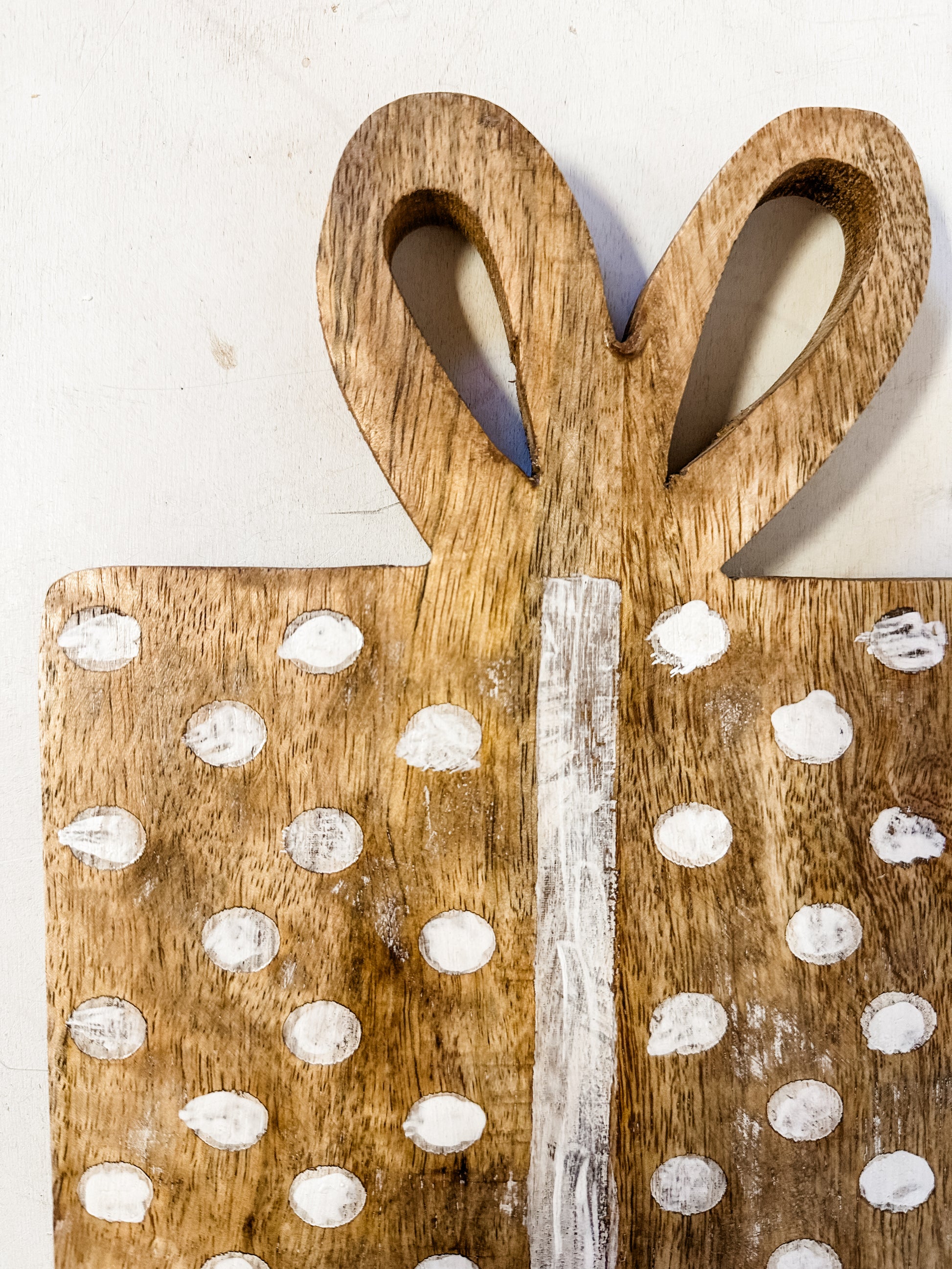 mango wood gift shaped cheese cutting board with dots and bow shaped handle at The Rustic Barn in Killingworth CT