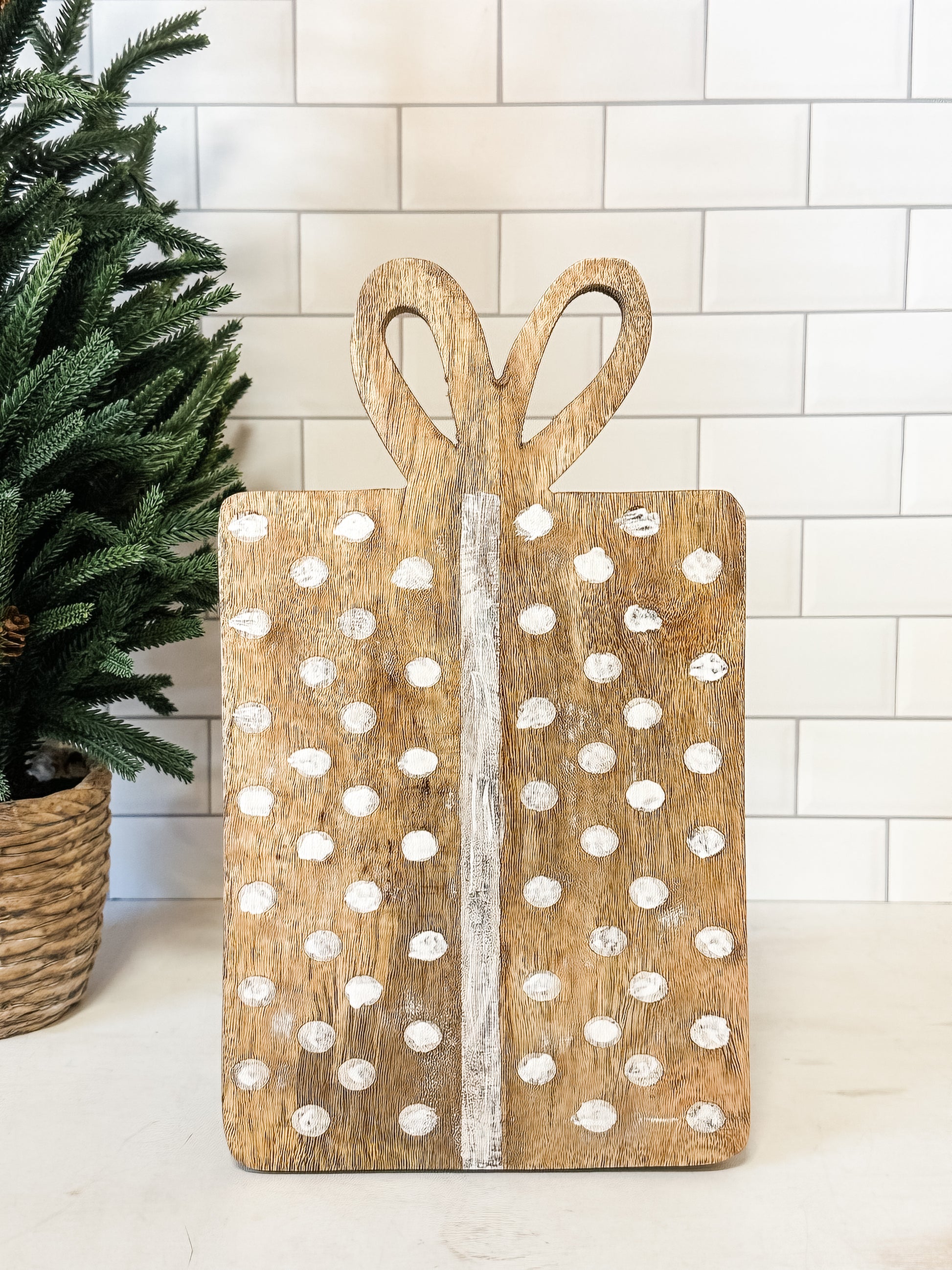 mango wood gift shaped cheese cutting board with dots and bow shaped handle at The Rustic Barn in Killingworth CT