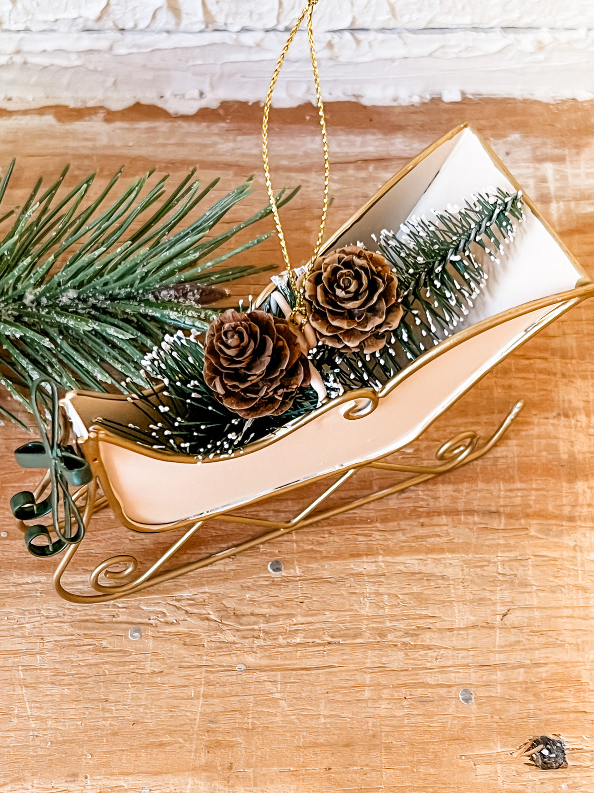 metal cream sleigh ornament with bottle brush trees in it at the rustic barn in Killingworth ct