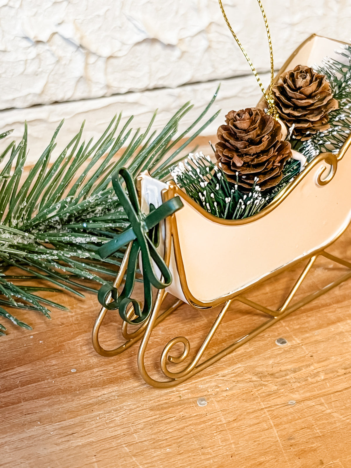 metal cream sleigh ornament with bottle brush trees in it at the rustic barn in Killingworth ct