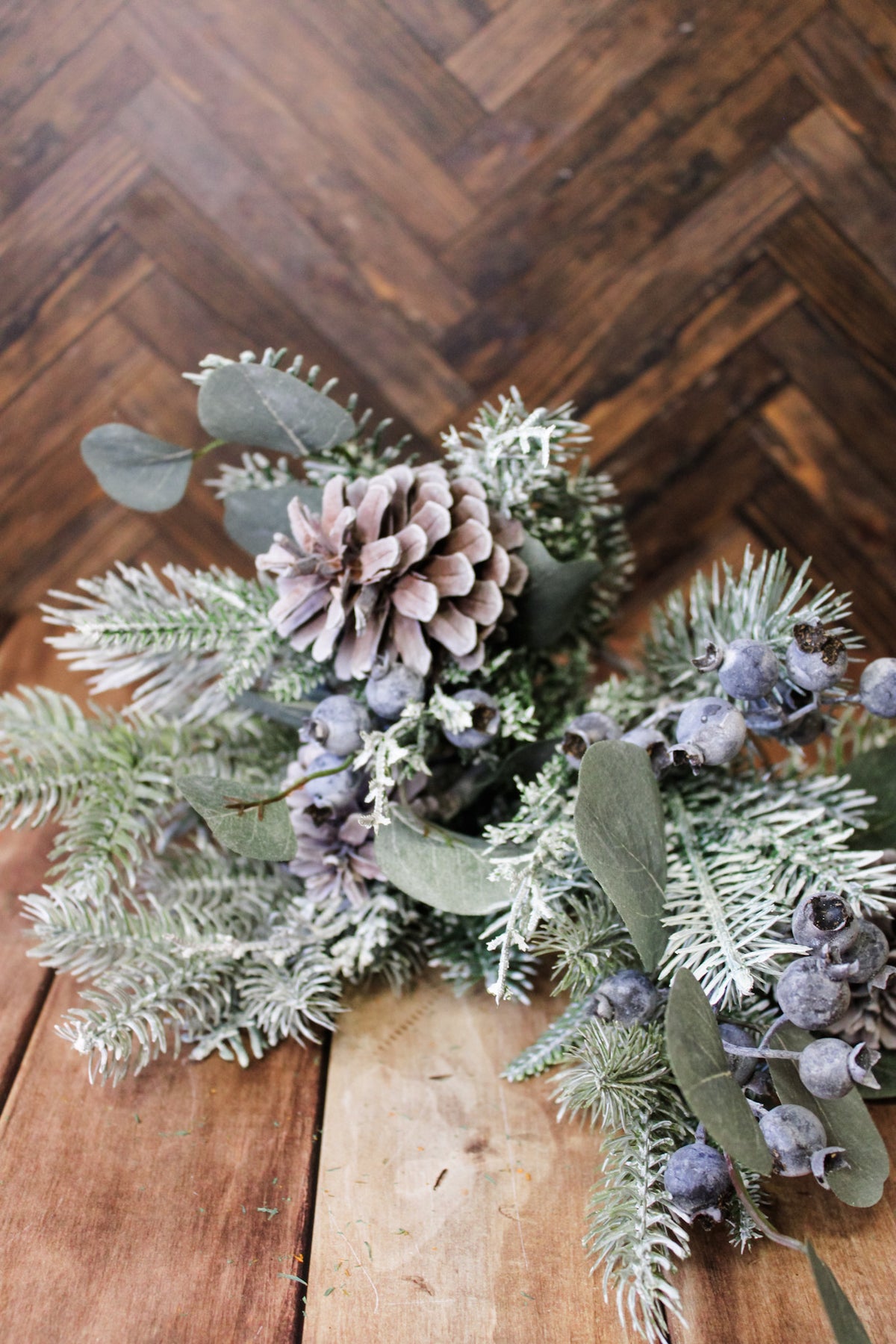 Mixed pine winter greenery for the home with pinecones and blueberries and leaves for christmas and holiday decor with snow frosted pine leaves for sale at the rustic barn in Killingworth, CT
