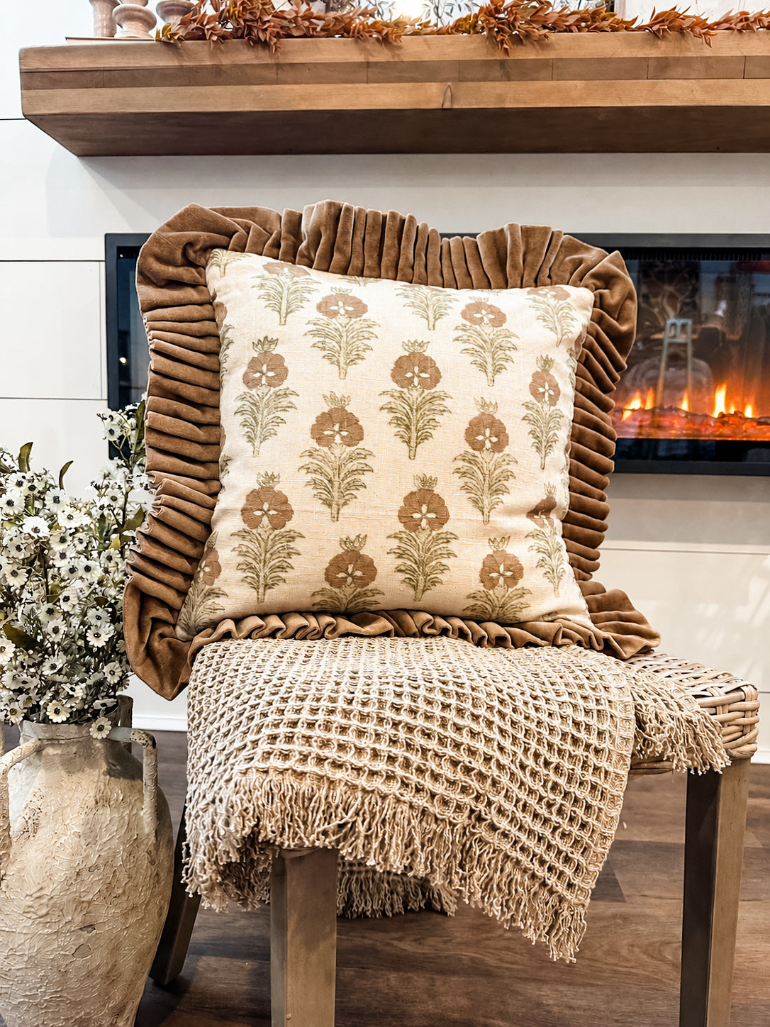 fall pillow and throw on chair in front of fire at the rustic barn in killingworth ct