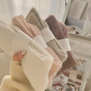 Set of four pairs of socks in beige, brown, and pink held together with a white band at the rustic barn in killingworth ct