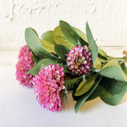 Bouquet of pink flowers with green leaves on a light background