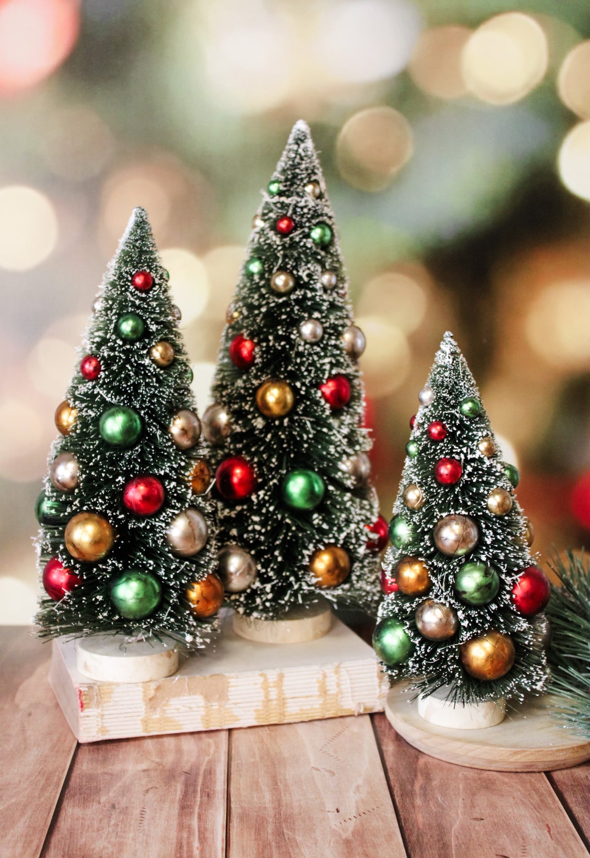 Vintage beaded bottlebrush trees with multicolored christmas bulbs and snowy white caps on the tree for sale at the rustic barn in Killingworth, CT