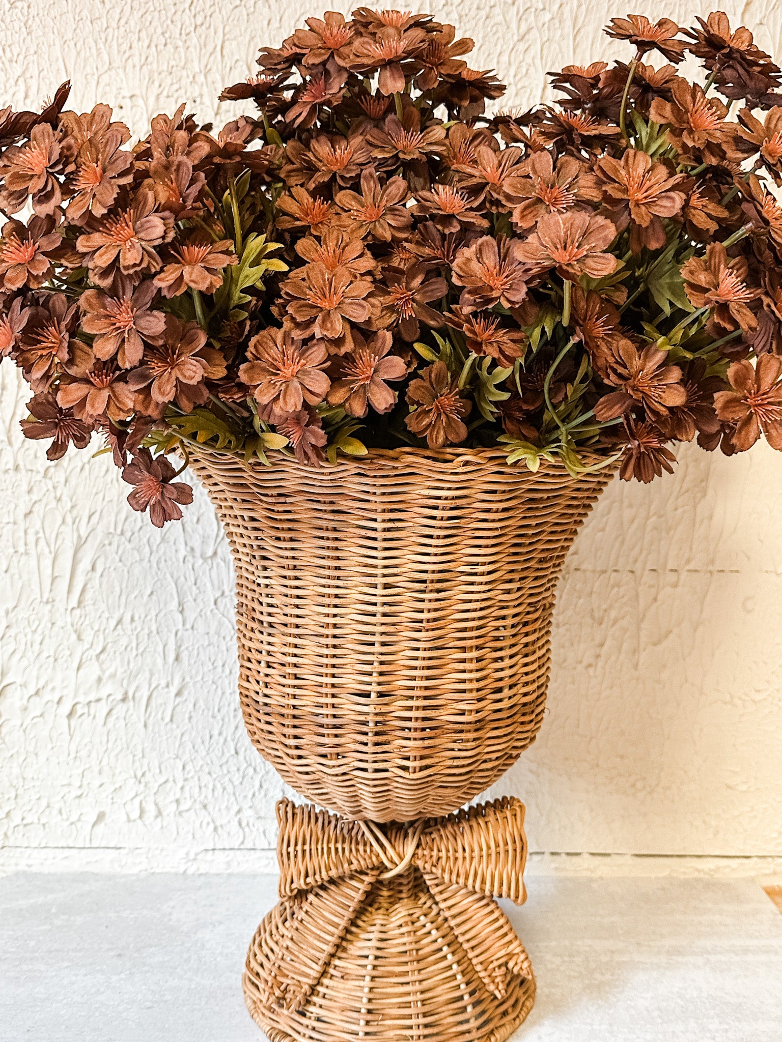 woven rattan footed floral container with a bow at the rustic barn in killingworth ct