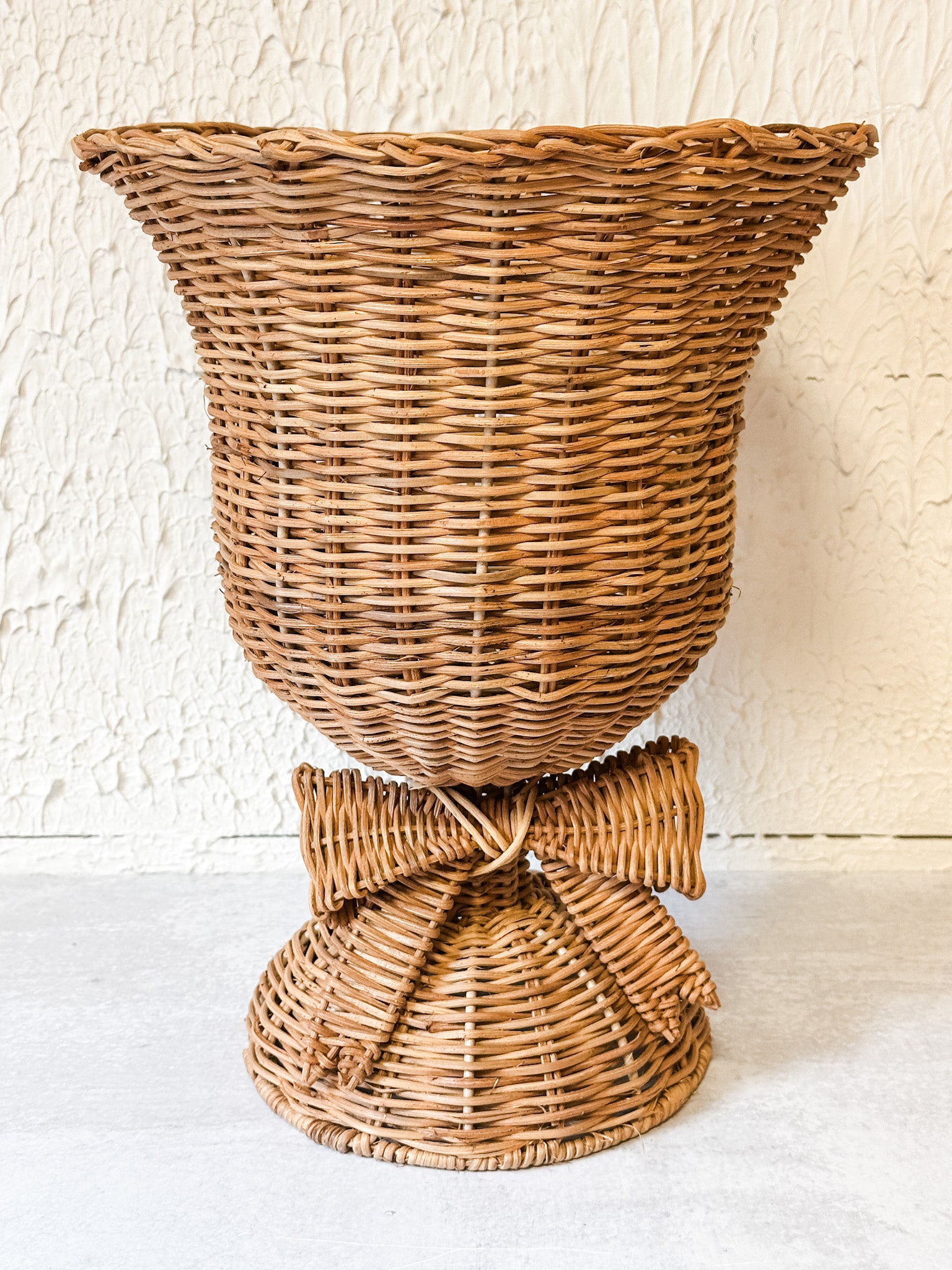 woven rattan footed floral container with a bow at the rustic barn in killingworth ct